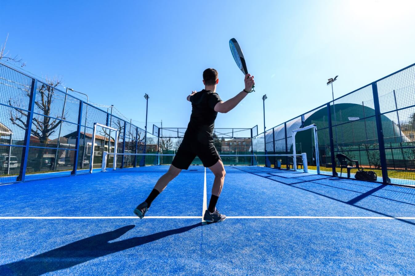 court de Padel à l'extérieur avec un joueur qui se prépare à frapper la balle avec sa raquette