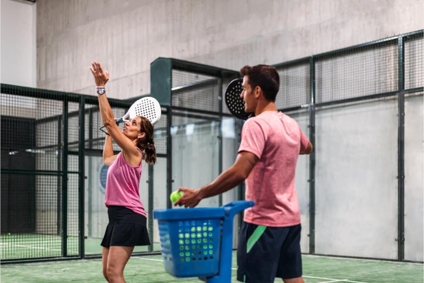 Homme et femme qui tiennent une raquette chacun, sur le terrain de Padel