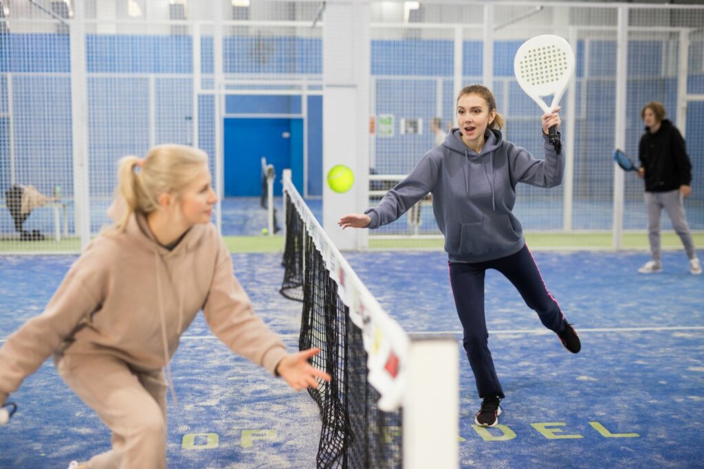 2 joueuses de Padel près du filet, prêtent à frapper la balle
