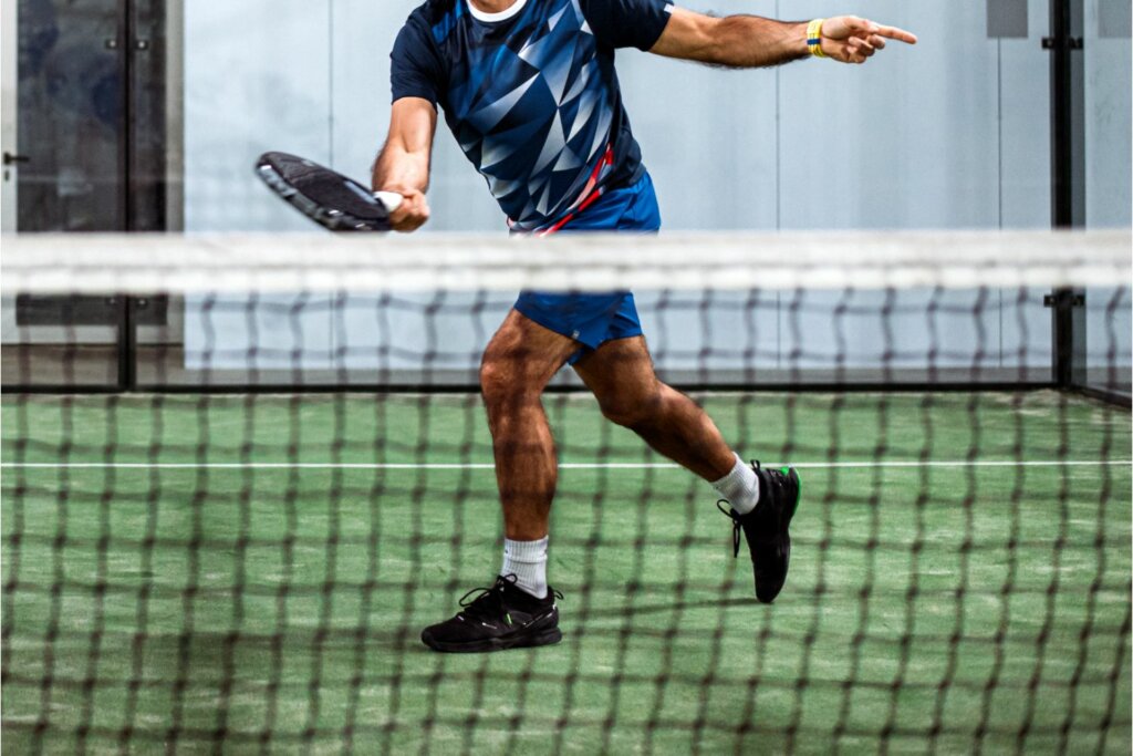 joueur de Padel portant tenue et chaussure noire avec raquette à la main