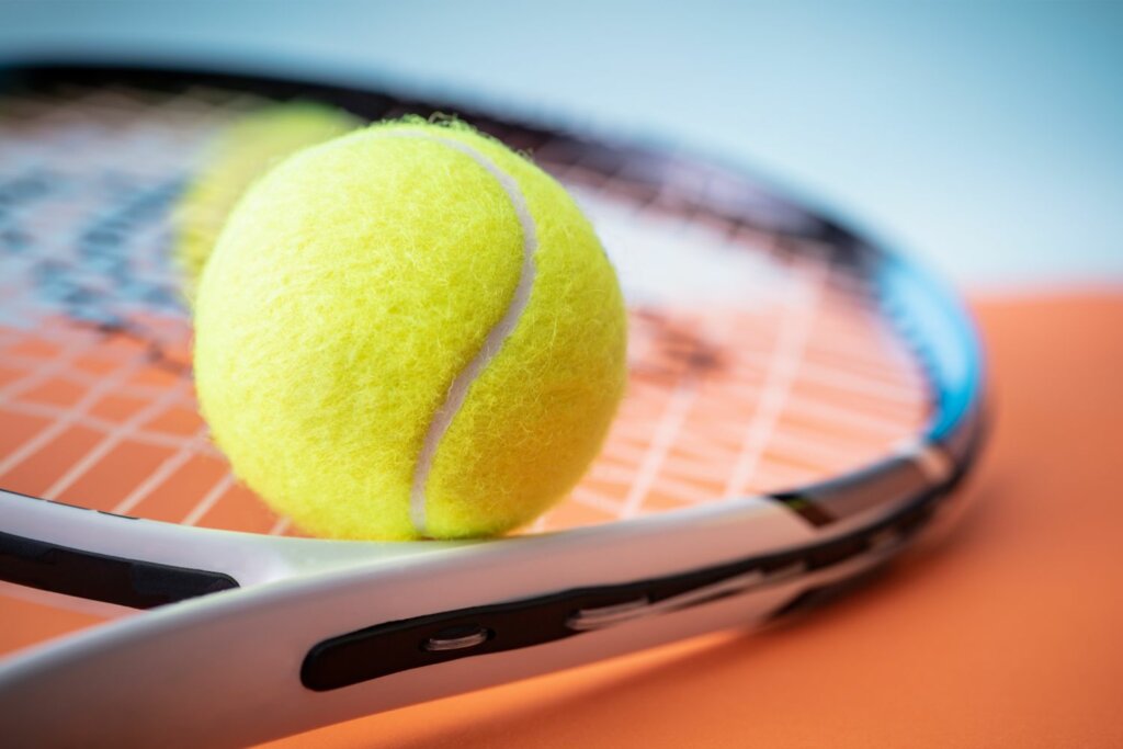 raquette de tennis sous des balles, placées sur une table